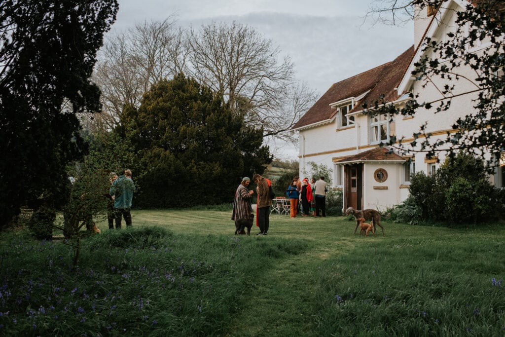 Pictures of a cosy Dorset coast cottage surrounded by lush greenery, with visitors enjoying the outdoor space.